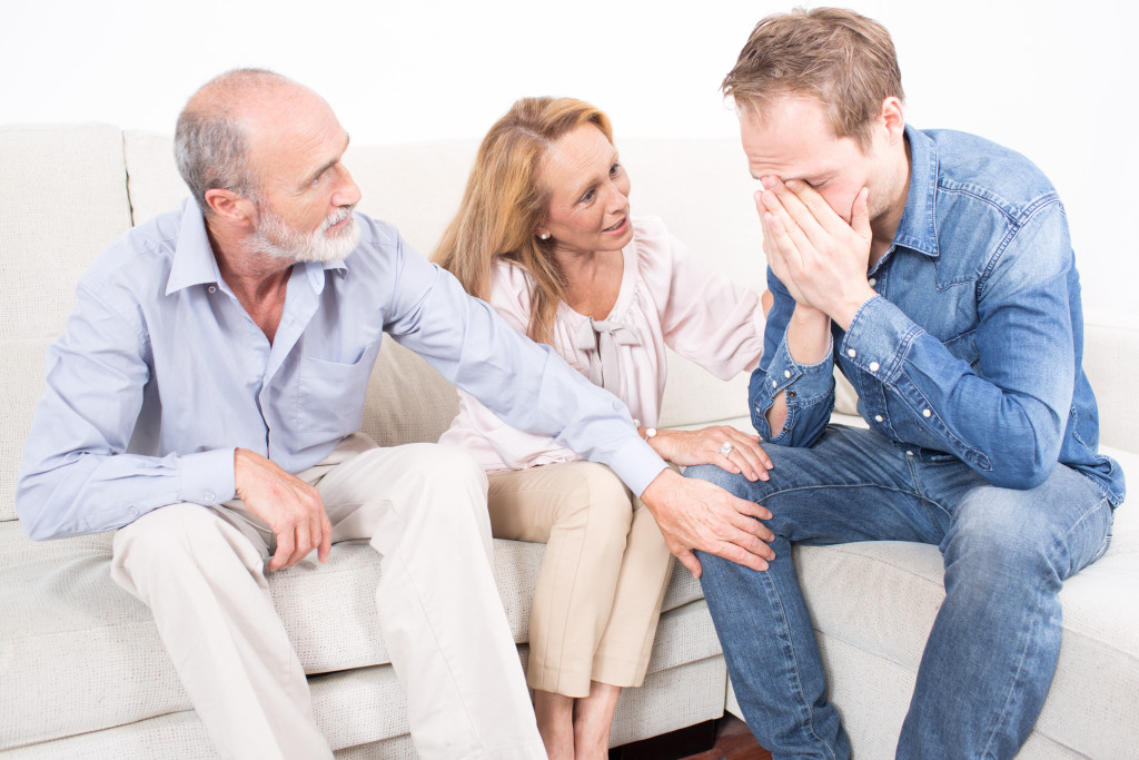 man crying in front of parents