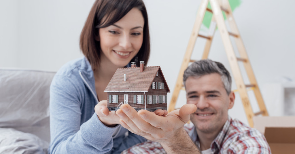 two people looking at a house diorama