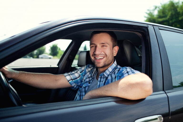 man smiling inside his car